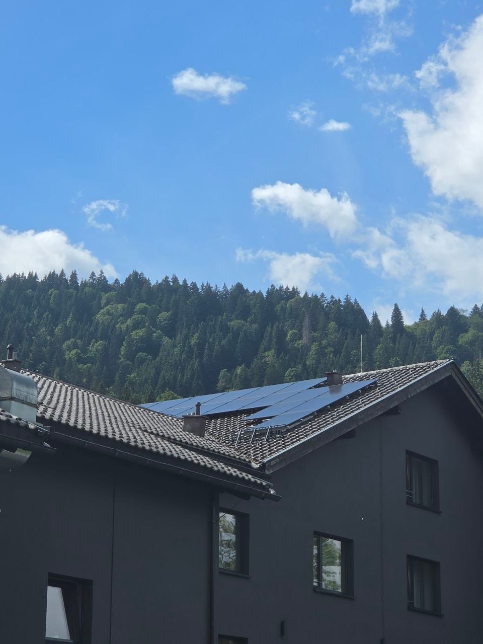 Schwarze Solarmodule auf einem dunklen Ziegeldach
