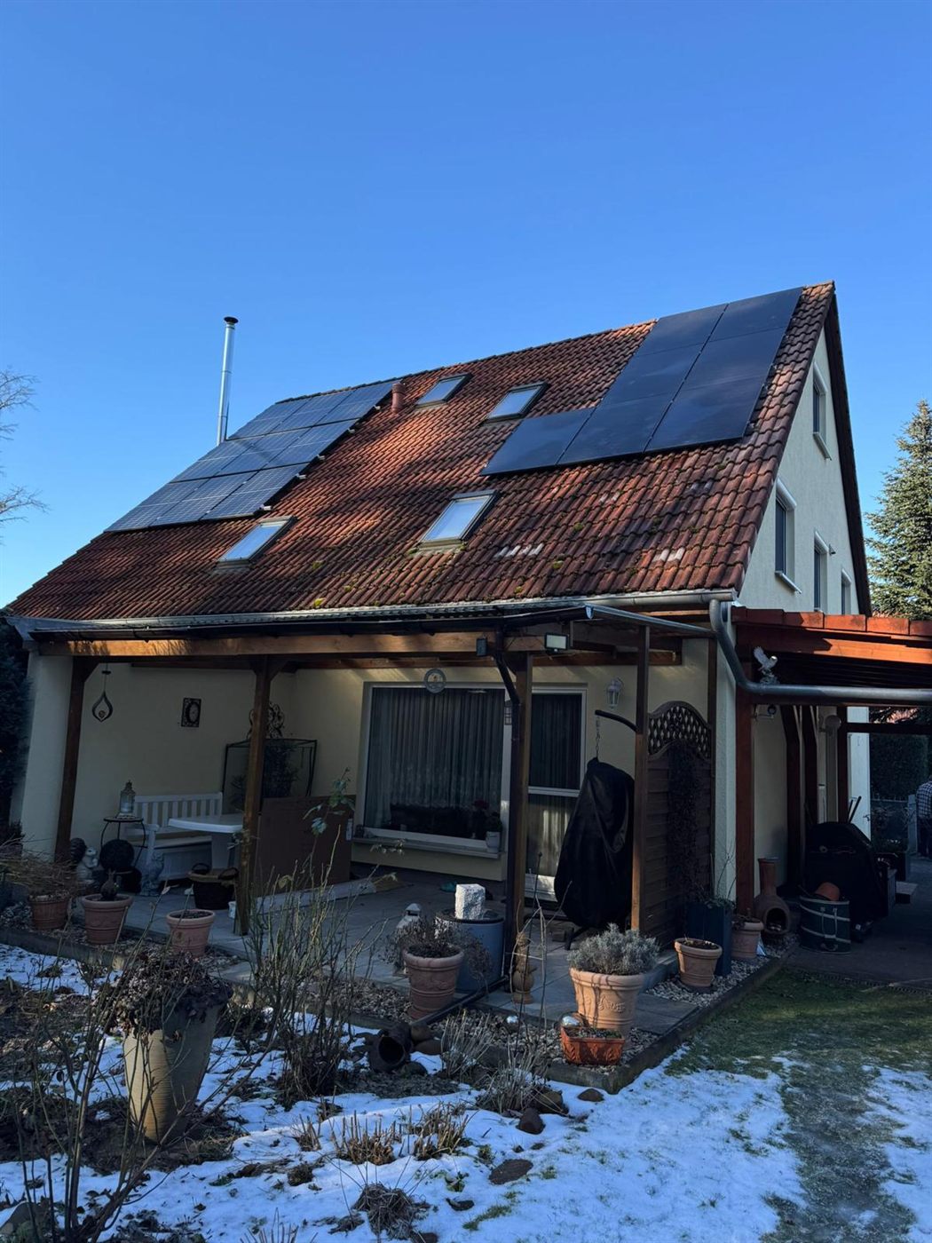 Einfamilienhaus mit rotem Ziegel-Satteldach und zwei belegten Photovoltaik-Teilflächen