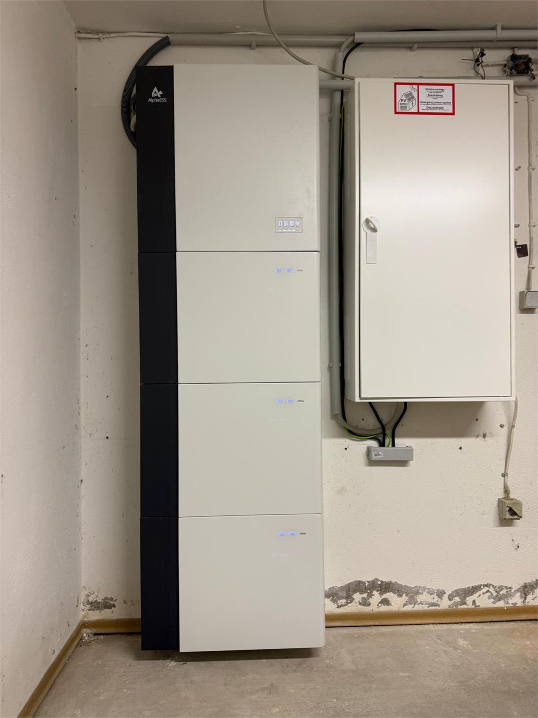 Hoher Batteriespeicher im Keller, direkt daneben der Zählerschrank an der Wand