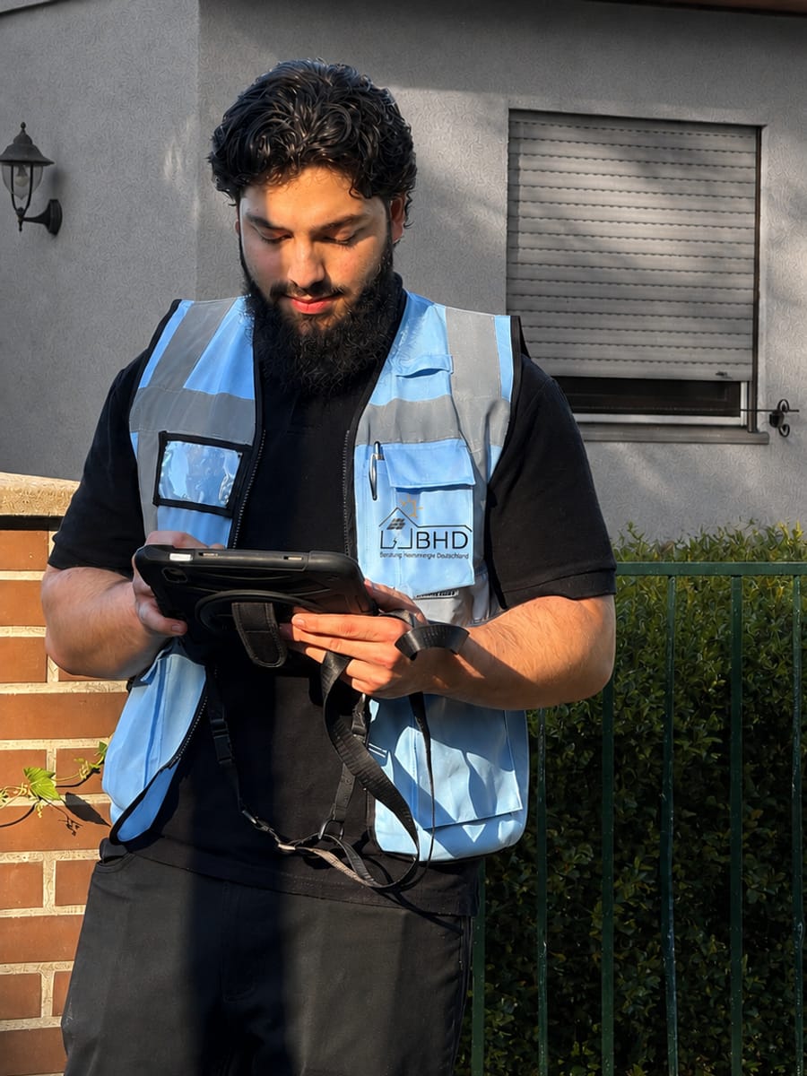 Kürşat Yıldırım, Geschäftsführer von BHD, erfasst bei einem Vor-Ort-Termin die Daten eines Einfamilienhauses auf dem Tablet.